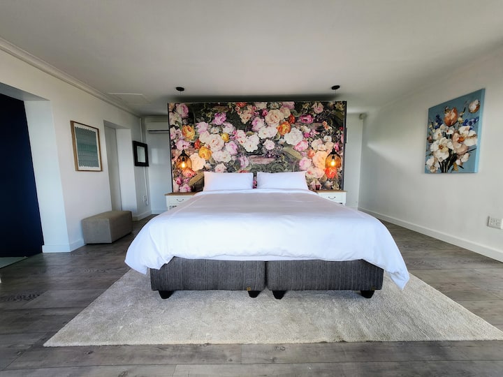 Krevet king size s dodatnom dužinom s posteljinom od egipatskog pamuka i jastucima king size. Krevet je okrenut prema prozorima koji gledaju na lažni erker.