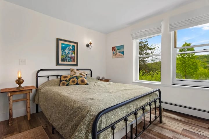 Cómodo dormitorio en el piso principal con una acogedora cama tamaño queen, luz natural y vistas tranquilas, perfecto para una noche de descanso después de días ajetreados explorando o asistiendo a eventos.