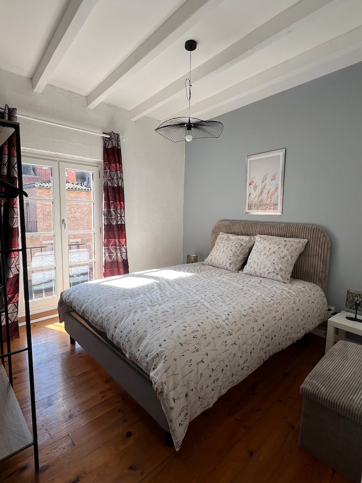 Première chambre comprenant un lit double, ainsi qu'un espace rangement avec étagères et penderie. 