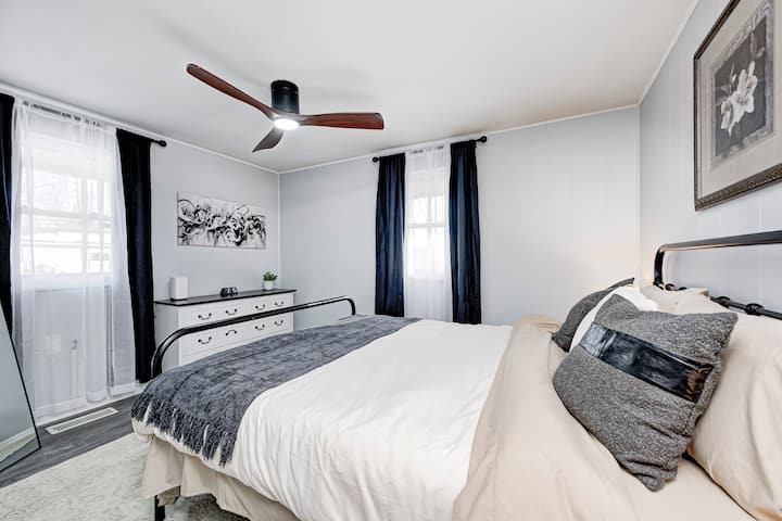 Светла, удобна спална соба со повеќеслојна неутрална постелнина и модерен вентилатор на таванот. Природната светлина го исполнува просторот, клупата за складирање во подножјето на креветот содржи дополнителни јоргани, а интернет рутерот е погодно сместен во оваа соба.