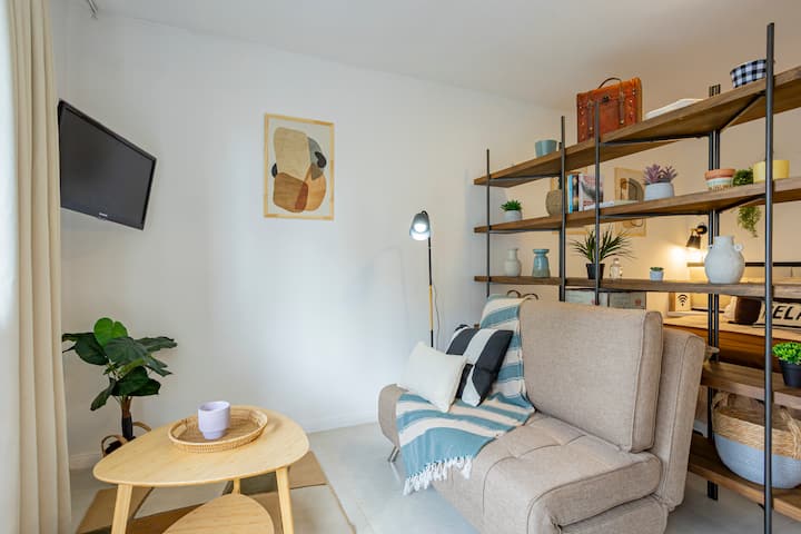 סלון מואר ונוח, עם ספה נפתחת לשני אנשים קטנים (ילדים), טלוויזיה ופרטי נוי בגוונים חמים. כוננית מוסיף סגנון ומחלק את החדר בעדינות, ויוצר חלל פרקטי ונעים.