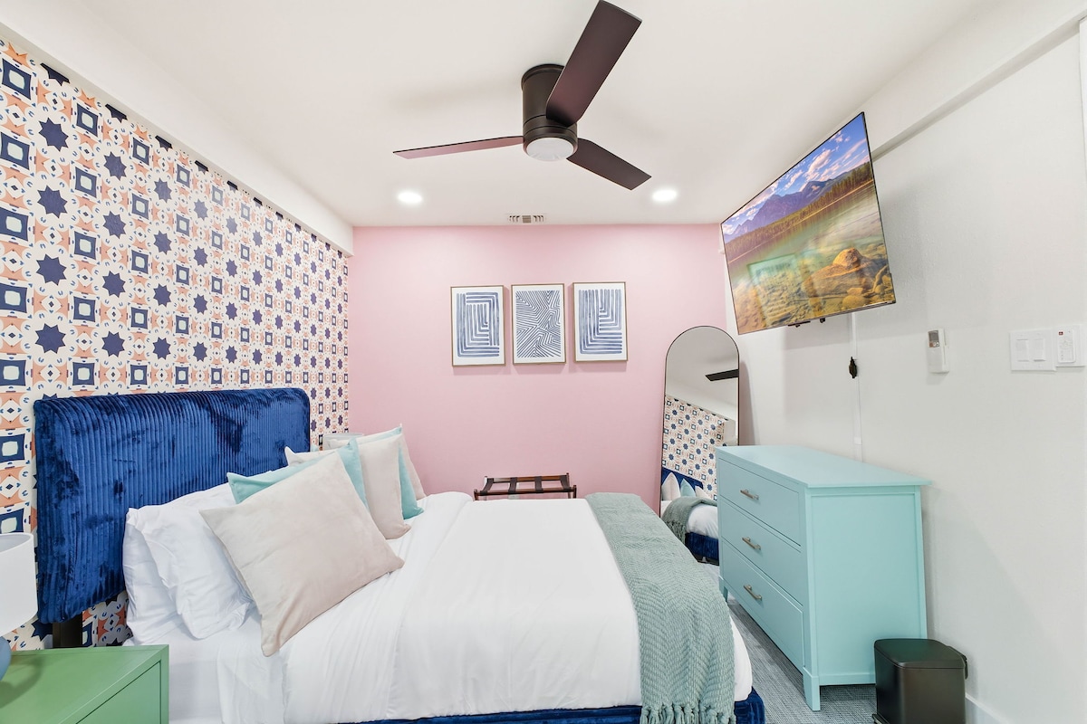 ملاذ غرفة نوم ساحر: ديكور نابض بالحياة، وأغطية فاخرة، وتلفزيون مثبت على الحائط في انتظارك للاسترخاء!