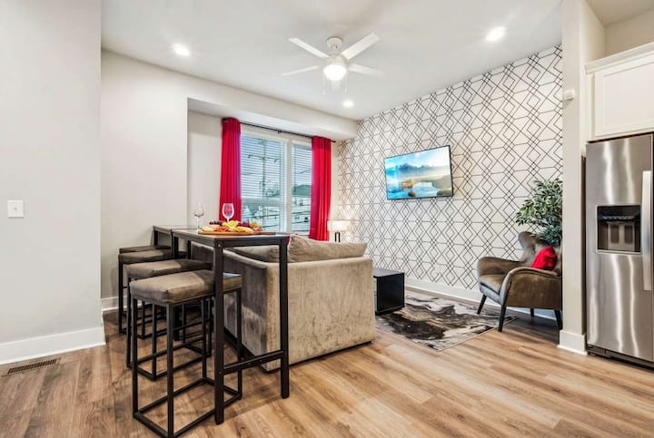 Sectional seating and a bar-height table turn the living room into the gathering spot where the group lands after exploring Nashville's honky-tonks