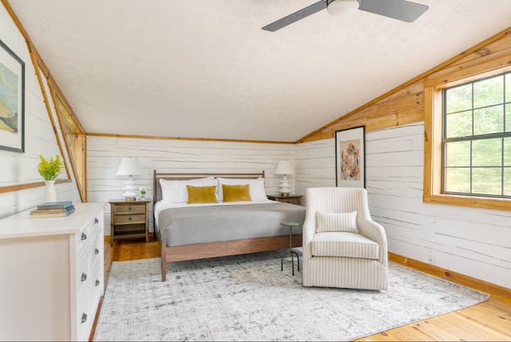 Cama tamaño king grande en el dormitorio principal de la planta superior con baño privado con bañera.