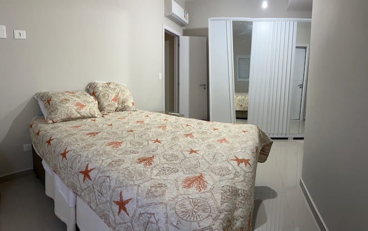Suíte confortável com cama queen size, amplo espaço de armazenamento, ar condicionado e banheiro privativo completo