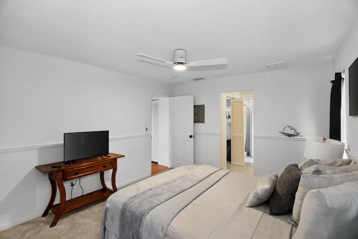 Cómodo dormitorio principal con cama tamaño queen y sábanas suaves para un sueño reparador. Equipado con un televisor Roku de 50 pulgadas.