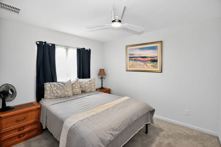 Dormitorio bien equipado con sábanas limpias, tonos costeros relajantes y cama tamaño queen.