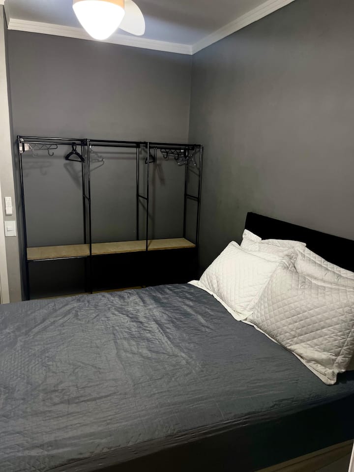 Dormitorio uno con 1 cama doble, ventilador de techo y lugar para guardar la ropa.