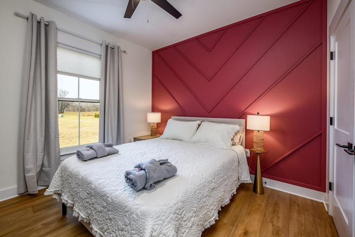 Dhomë miqsh me krevat dopio "queen". Dollapi ka rafte dhe sirtarë të integruar me hapësirë për varje. 