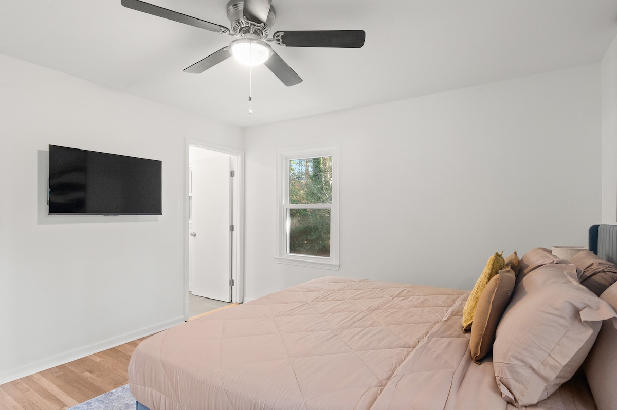 Útulná spálňa s posteľou veľkosti King a TV, ideálna na odpočinok po dlhom dni.