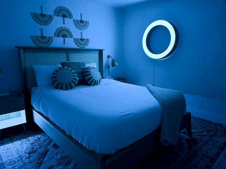 Dormitorio tamaño queen con iluminación ambiental y TV