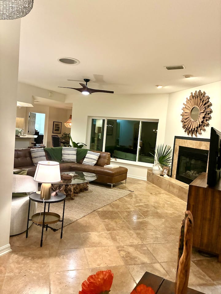 Главна дневна соба со голем прозорец со поглед кон базенот, вентилатор на таванот и поглед кон базенот