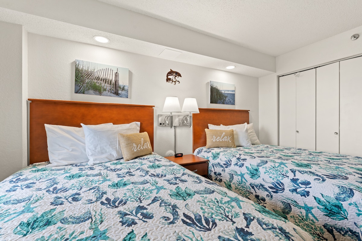 Dormitorio de invitados con dos lujosas camas dobles, decoración inspirada en la playa y un espacioso armario para guardar la ropa. Un espacio cómodo y acogedor ideal para familias o amigos.