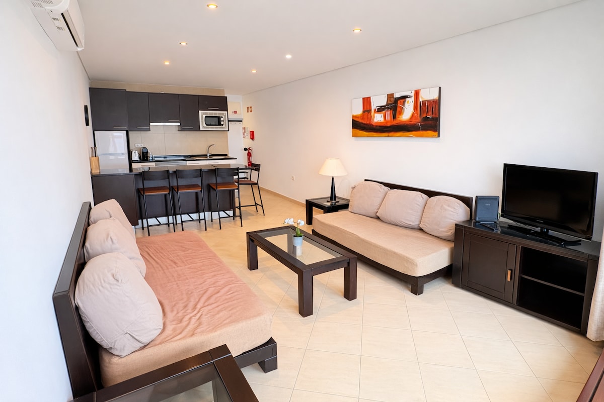 La luminosa y cómoda sala de estar cuenta con dos cómodos sofás (fácilmente convertibles en camas), aire acondicionado, TV de pantalla plana y un diseño de planta abierta que se conecta a la perfección con la cocina totalmente equipada. 