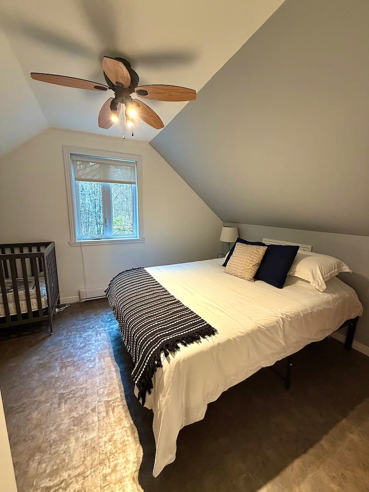 1st upstairs bedroom with a queen-size bed and a crib
