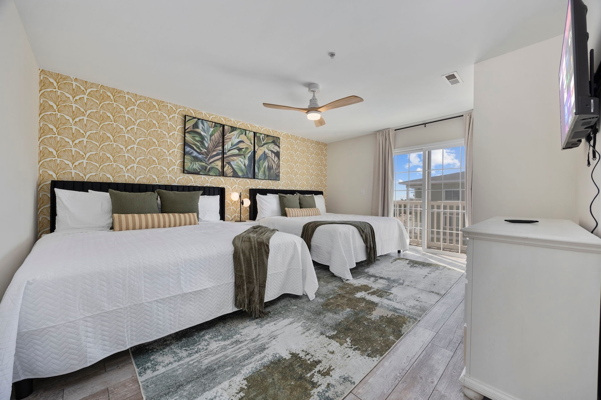 Tu espaciosa habitación con dos cómodas camas tamaño king, detalles costeros atrevidos y acceso al balcón para disfrutar del aire fresco y las vistas. Sal a contemplar las vistas hacia el muelle Cherry Grove.