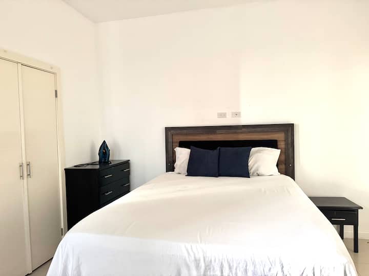 Chumba cha kulala cha wageni chenye starehe kilicho na kabati la nguo, bafu na roshani iliyo na mwonekano wa ajabu wa jiji. 