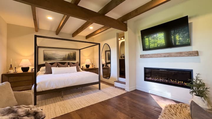The primary bedroom (downstairs) has incredible lake views, an attached half bathroom, electric fireplace, and dedicated workspace.