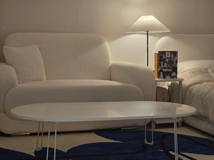 Et lavt bord er placeret ved siden af sofaen, så gæsterne kan sidde komfortabelt, mens de ser tv, nyder måltider eller deler snacks og drikkevarer med venner.
