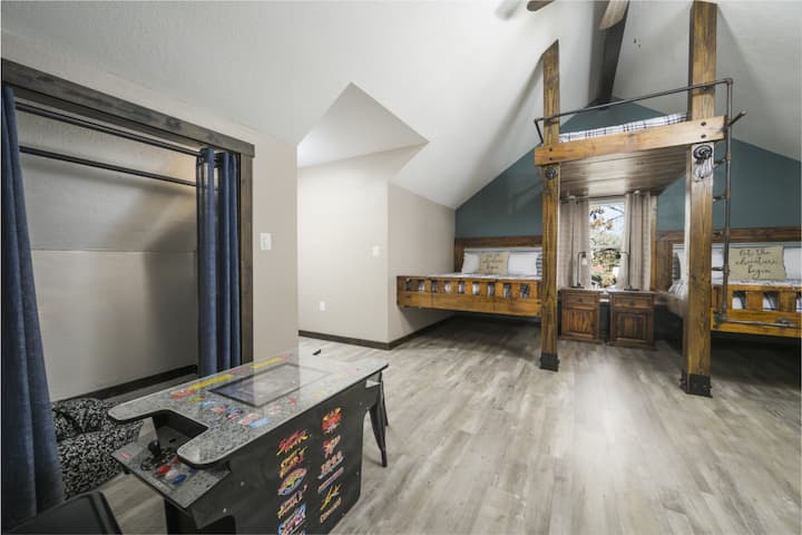 Au premier plan se trouve une table d'arcade multijoueur, proposant de nombreux jeux classiques qui procurent un plaisir immédiat aux enfants comme aux adultes. C’est l’endroit idéal pour des compétitions nocturnes, pour se divertir les jours de pluie ou pour occuper agréablement les enfants.
