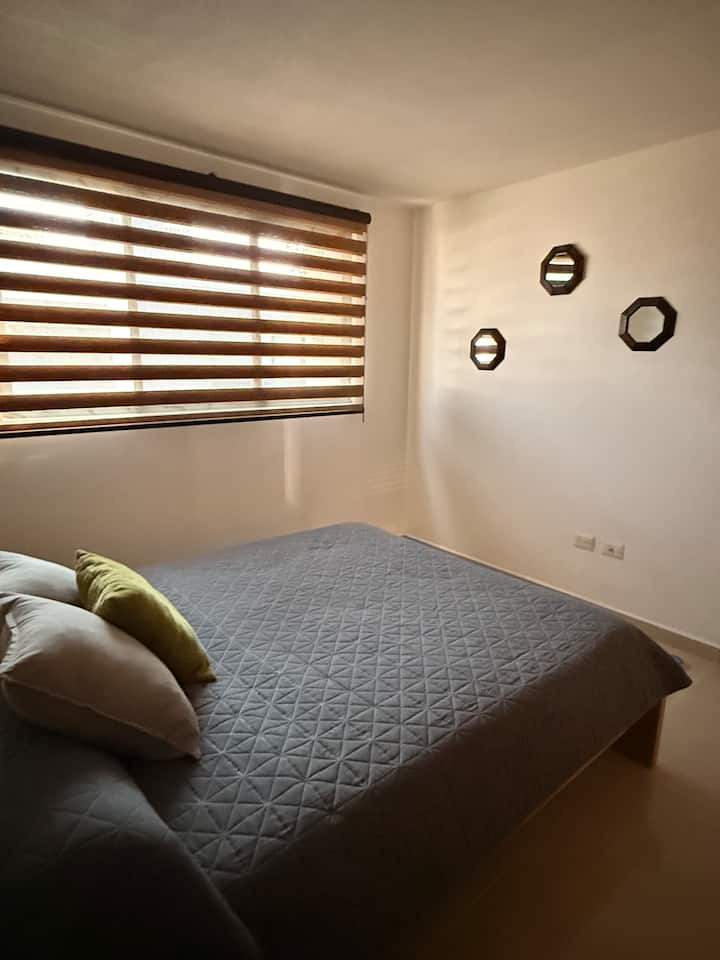 次卧室，配备标准双人床、床上用品、额外毯子、挂衣架、衣柜和全身镜。