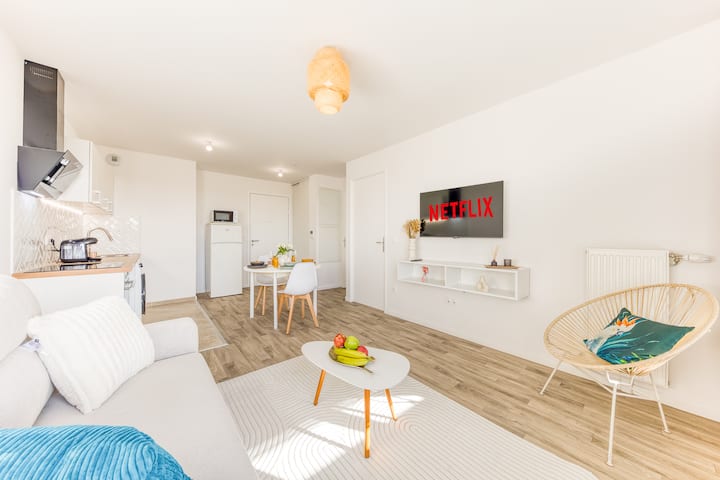 ห้องนั่งเล่นสว่างพร้อมโซฟาที่สะดวกสบายและทีวีจอแบน