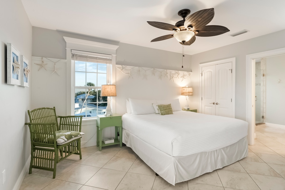 Svijetla i privlačna spavaća soba za goste s nježnim obalnim uređenjem i mirnim prirodnim svjetlom.