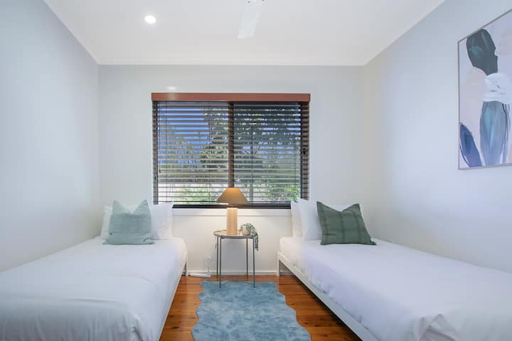 Dos camas individuales, tonos tranquilos y un estilo cuidadoso hacen que este espacio sea flexible para niños o amigos.