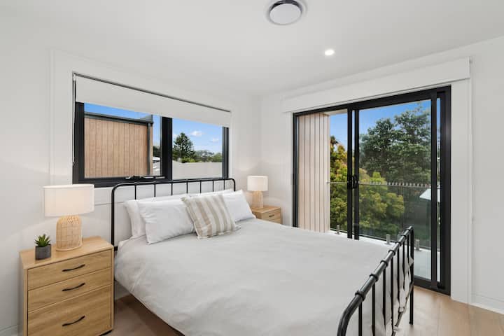 The third queen bedroom is drenched in natural light with direct access to the balcony.