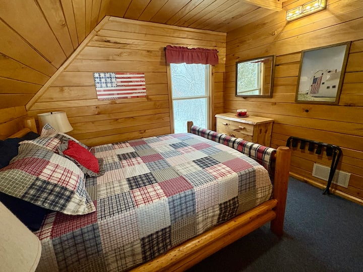 Slaapkamer boven met queensize bed en plafondventilator.