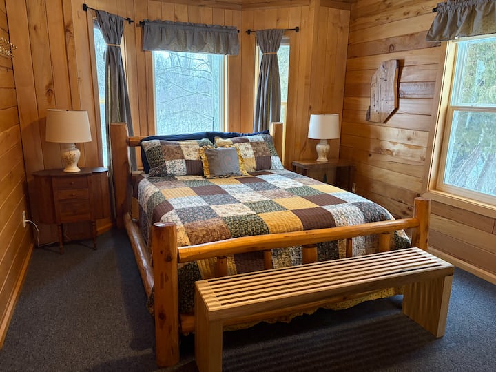 Slaapkamer op de begane grond met queensize bed, volledige kast en erker. 