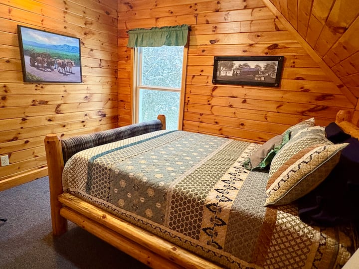 Slaapkamer boven met queensize bed en plafondventilator. 