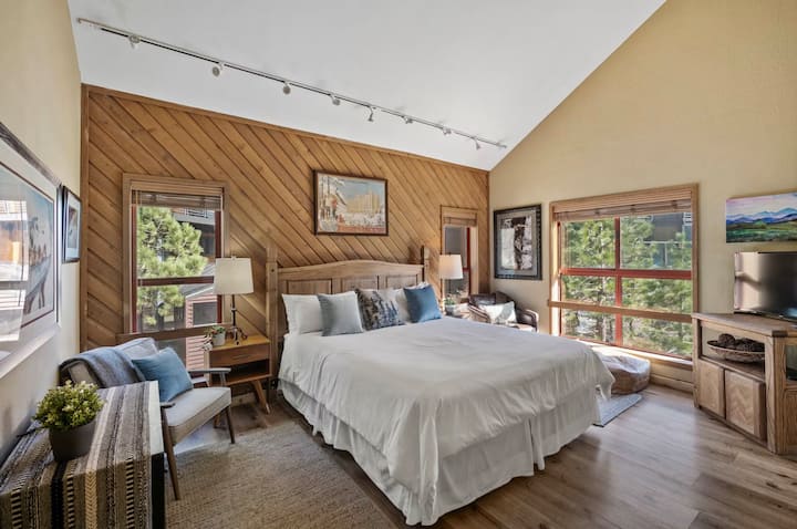 Retírate a la máxima comodidad de esta suite principal en esquina. Disfruta de una cama tamaño king, impresionantes vistas desde ventanas de gran tamaño, un televisor inteligente y todos los detalles necesarios para una estancia tranquila: sillas de lectura, escritorio y techos abovedados.