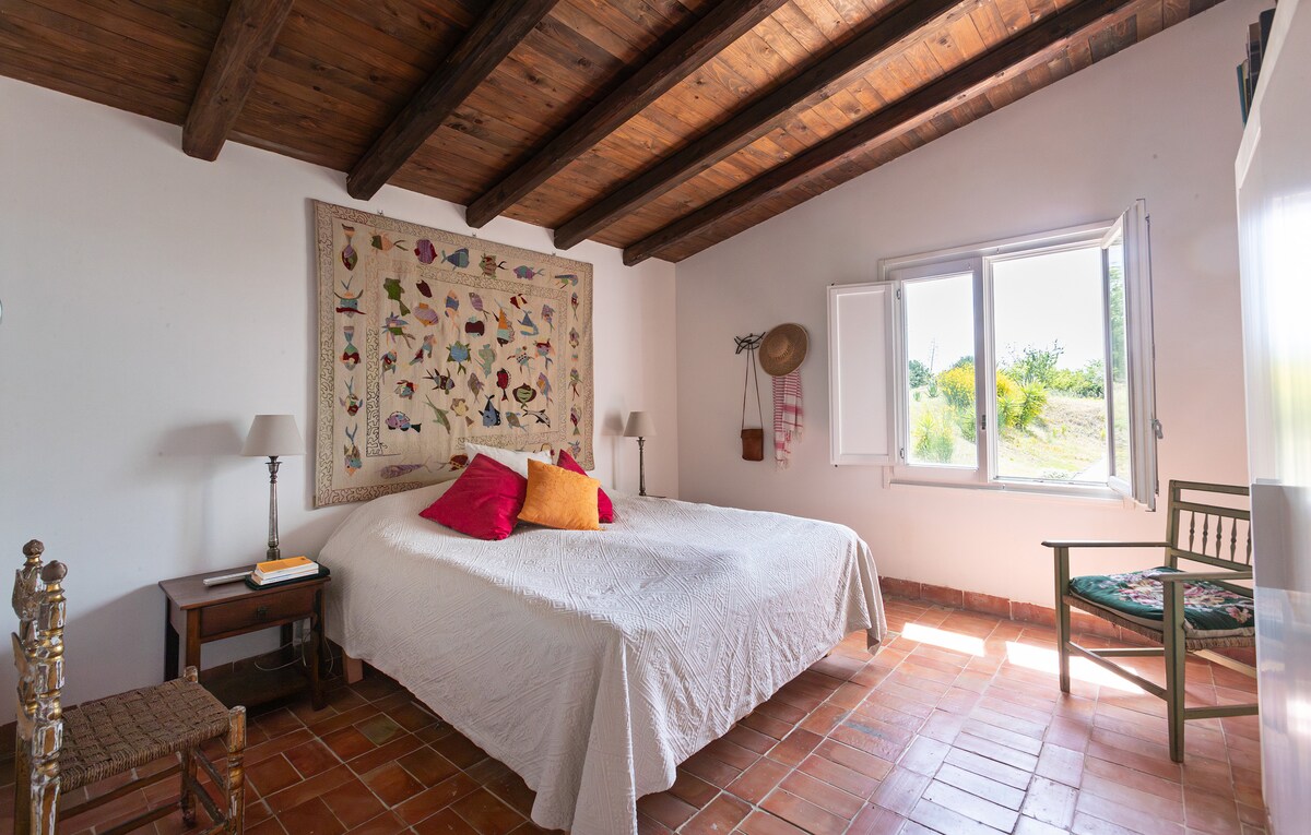 Husets rymligaste sovrum med  eget badrum med badkar. Morgonsol och utsikt mot poolområdet. 