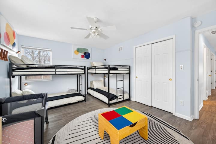 Um quarto divertido e confortável ideal para crianças ou adultos, com dois beliches que acomodam quatro pessoas e um cercado para bebês. Perfeito para famílias ou grupos que viajam com crianças, dando a todos seu próprio espaço para descansar e relaxar.