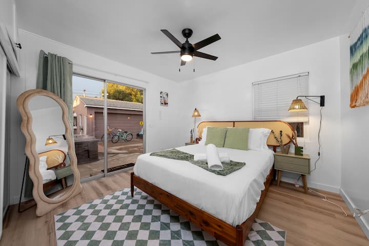 1号卧室配有一张标准双人床，可通往室外区域，为您提供一个明亮、舒适的休息和充电空间。 吊扇和充足的储物空间使这个房间更加便利。