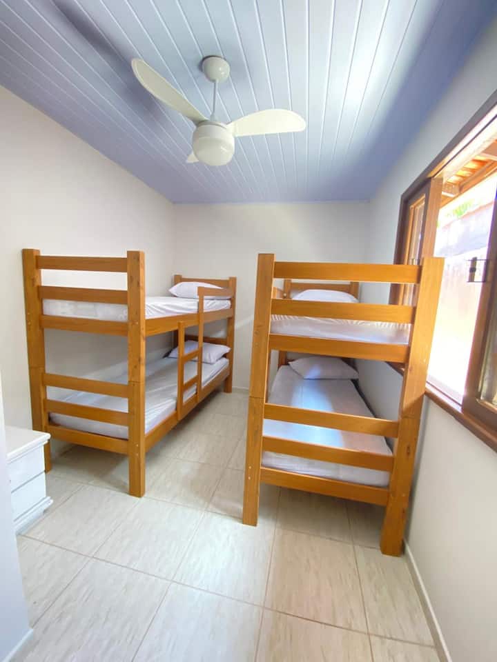 საძინებელი ორი ორსართულიანი საწოლით და ჭერის ვენტილატორით.