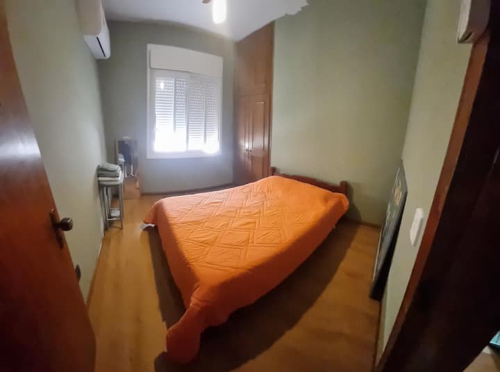 Habitación con cama doble, armario y aire acondicionado. 
Se puede ver el océano desde la ventana.