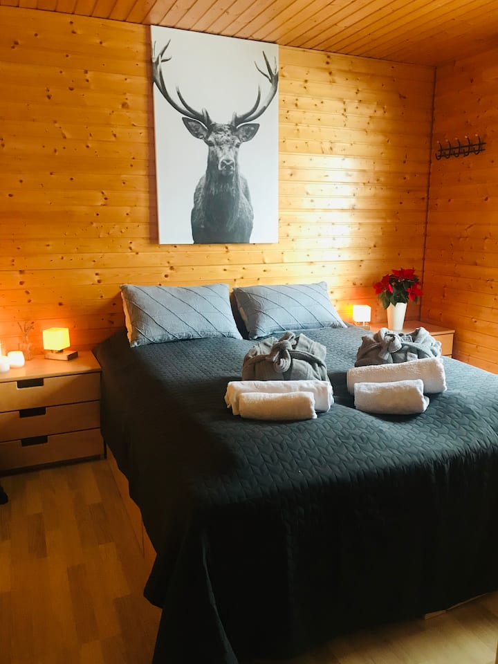 Hlavná spálňa na hornom poschodí s dverami na balkón a výhľadom na hory. Na uskladnenie je k dispozícii šatníková skriňa.