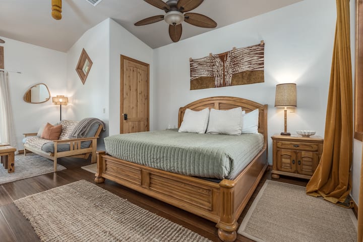 Spacious king bed area with raised ceilings and tropical-style fans for a breezy, relaxed vibe.