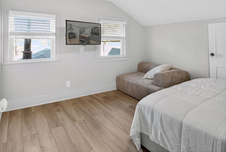 საძინებელში 2 არის საწოლი 152×203 სმ, LED‑განათების ჩარჩო, ტუმბო, Smart TV და მოდულური დივანი‑სავარძელი.