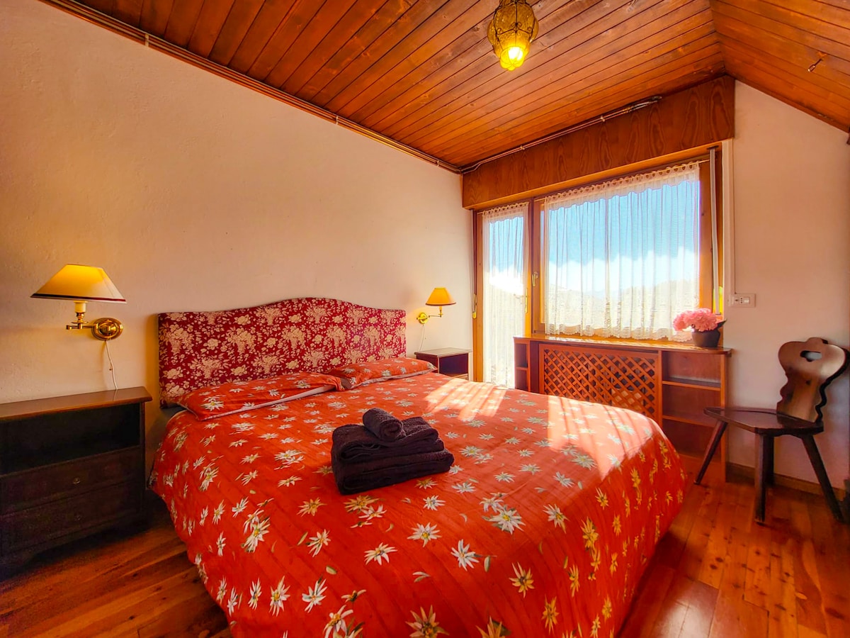 Relax in our master bedroom, with large windows that make it particularly bright.  The spectacular view creates a serene atmosphere, ideal for recovering energy and enjoying the beauty of the surrounding nature. 