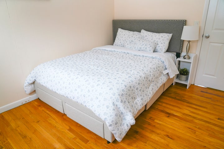 חדר שינה נעים עם מיטת קווין סייז אלגנטית עם מצעים רכים ותאורה חמימה.