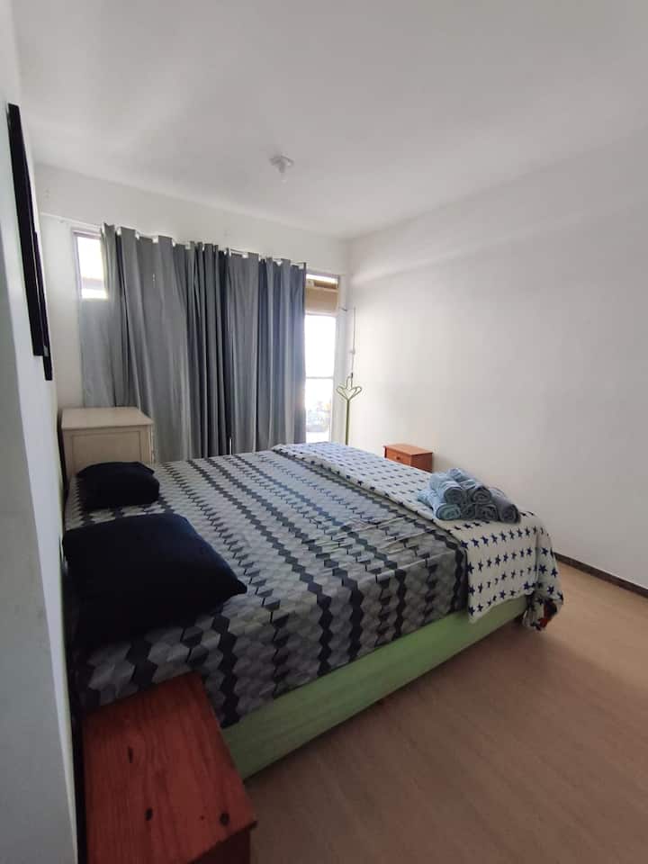 Chambre avec garde-robe, lit queen size, climatisation, garde-robe intégrée et balcon face à la mer