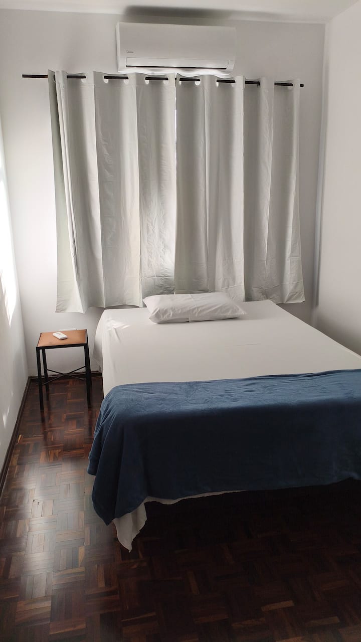 Dormitorio con cama queen, aire acondicionado frío y calor, ventana con cortina opaca para no perturbar su sueño y cobijas para abrigarse en los días fríos.