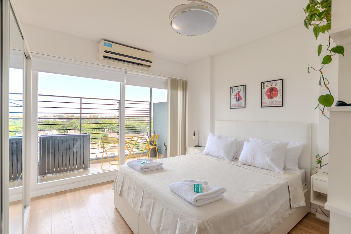 Chambre lumineuse, avec accès à l'extérieur et vue ouverte sur la ville.
