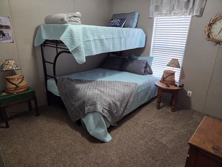 El dormitorio de invitados tiene una litera con una cama tamaño queen en la parte inferior y una cama individual en la parte superior. Silla disponible (no aparece en la foto) y Smart TV.