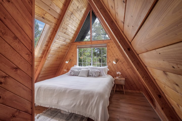 King bedroom with crisp white linens and warm wood tones.