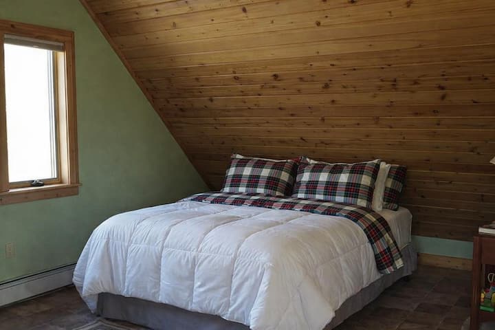 מיטת קווין בחדר שינה 4 נפרדת מהבית הראשי וממוקמת מעל המוסך. בחדר הזה יש גם מטבחון עם תנור, כיריים ומקרר, וחדר רחצה עם מקלחת. מתאים לאורחים שרוצים פרטיות מהבקתה הראשית. 