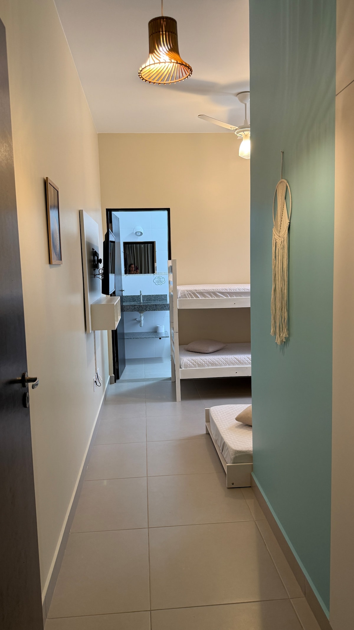 Suite compuesta por una litera y una cama individual, aire acondicionado + ventilador de techo, televisor inteligente y armario para guardar ropa.  